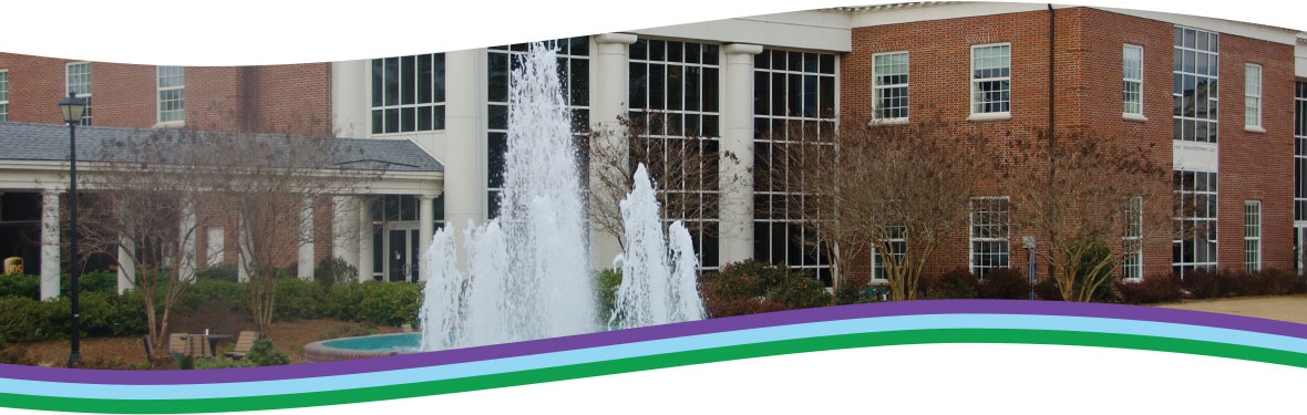 Exterior of brick University building with water fountain